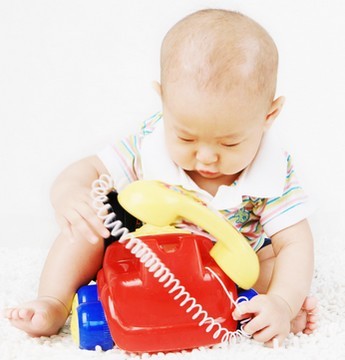 infant with toy phone